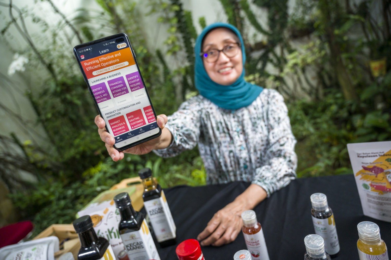 Jullie Hakim holds up the HerVenture app