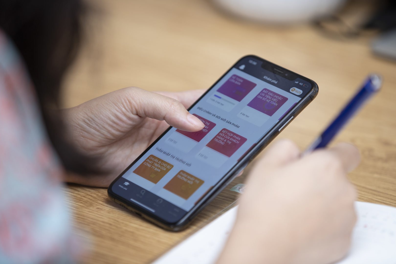 Quynh Nguyen, founder of AZCare, holds the HerVenture app and takes notes