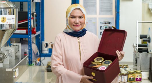 Shinta Aviyani, founder of Imago Raw Honey, and WEAVE alumna, holds up a box of her honey
