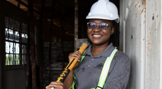 Nakaida Belle-Lindie poses with a sledge hammer at a construction site.