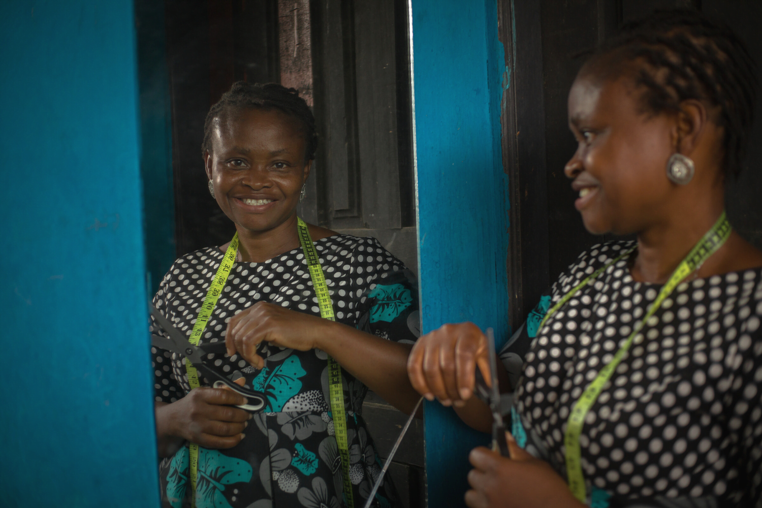 Odunayo Anyibuofu poses with scissors and measuring tape at her apparel company