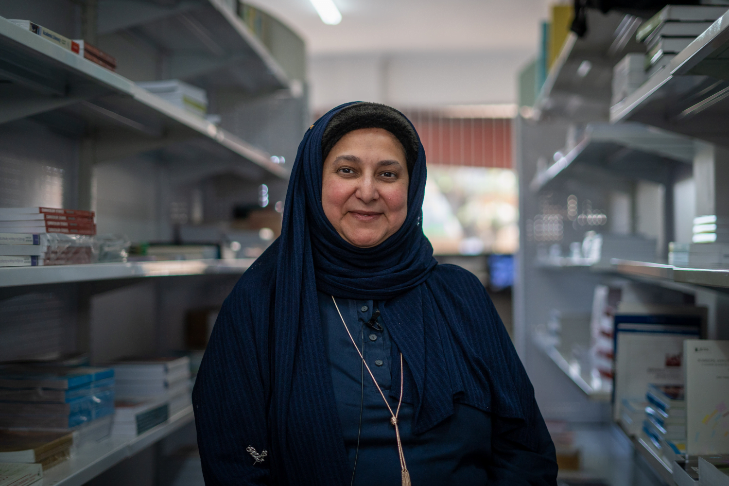 Shereen Cassim Hassim, a female entrepreneur, poses for a photograph with shelves of books.