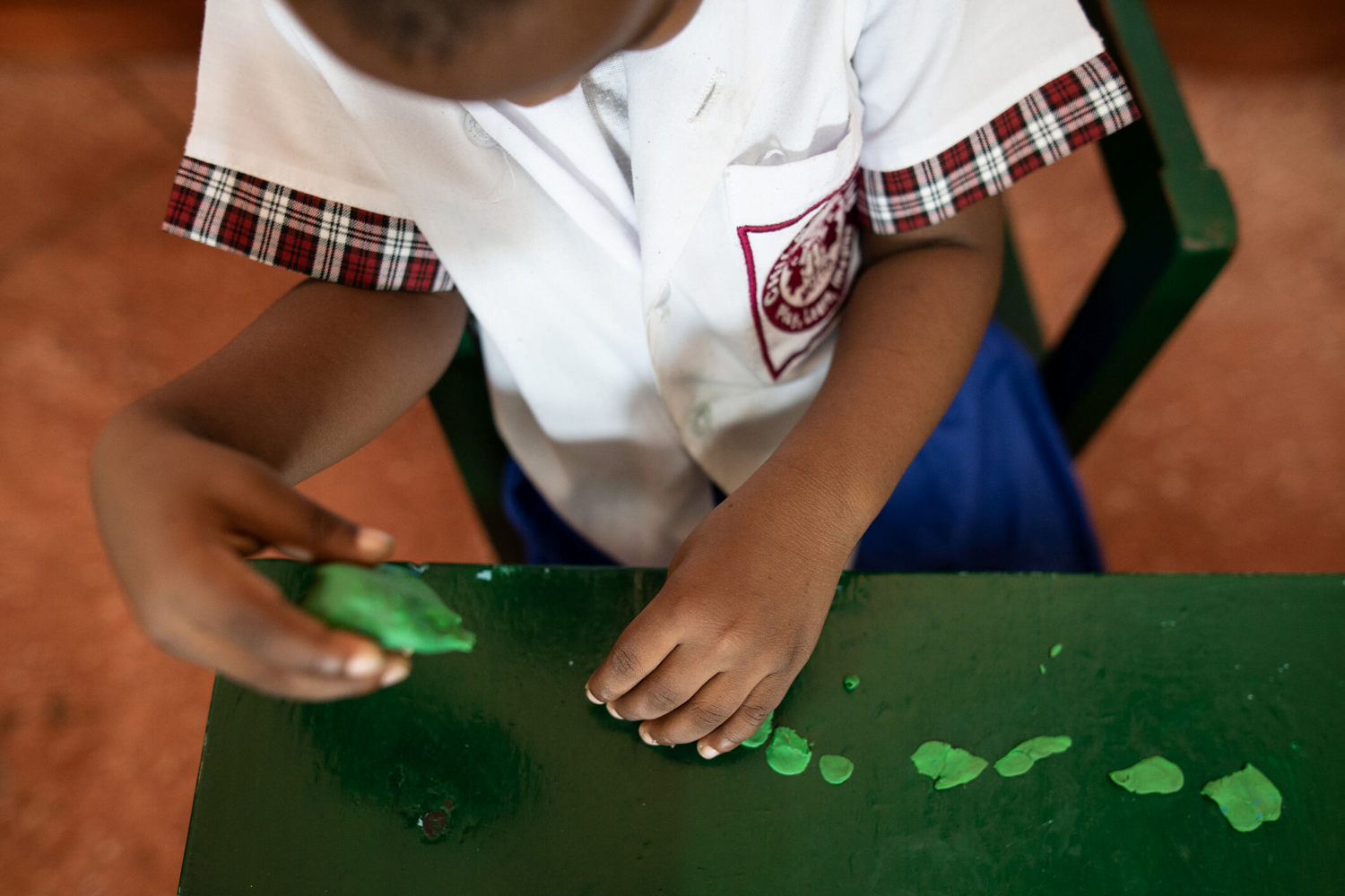child plays with clay at Children R Us in Guyana