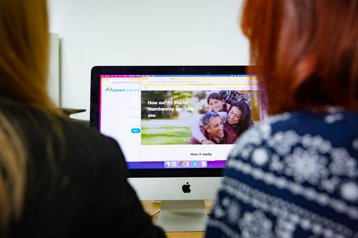 Over two women's shoulders, a computer screen is visible. The website displayed says 'How our PS Starter Membership can help you'