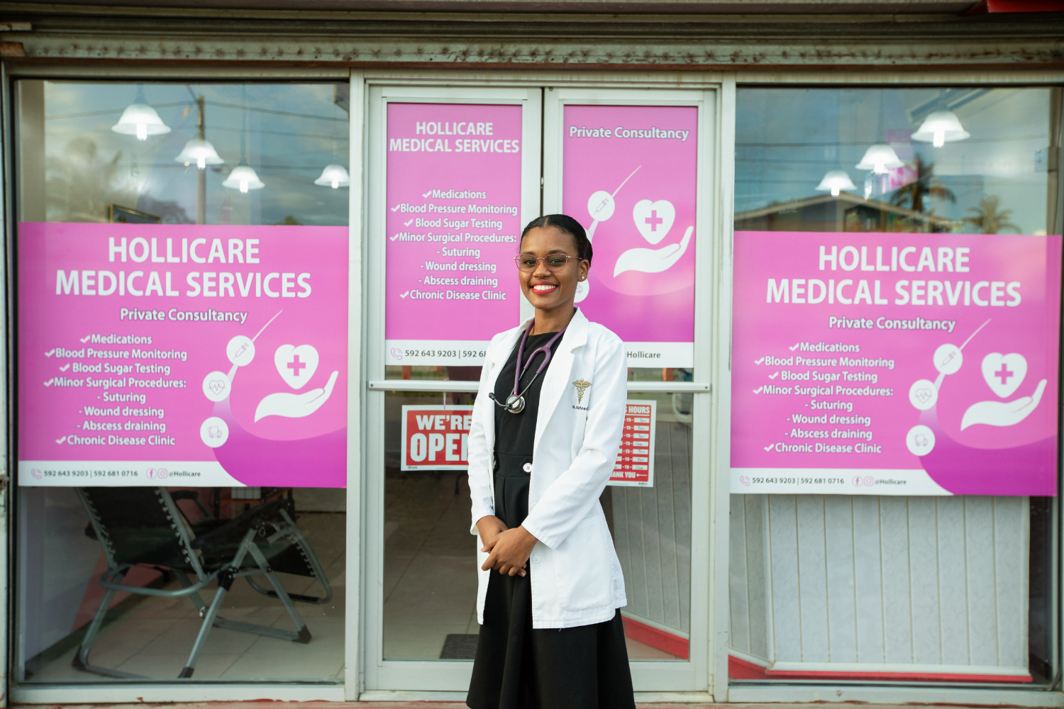 Dr. Hollina Alfred poses for a photograph in front of the entrance of her business, HolliCare, in Albouystown, Georgetown, Guyana. 24 June 2024.
