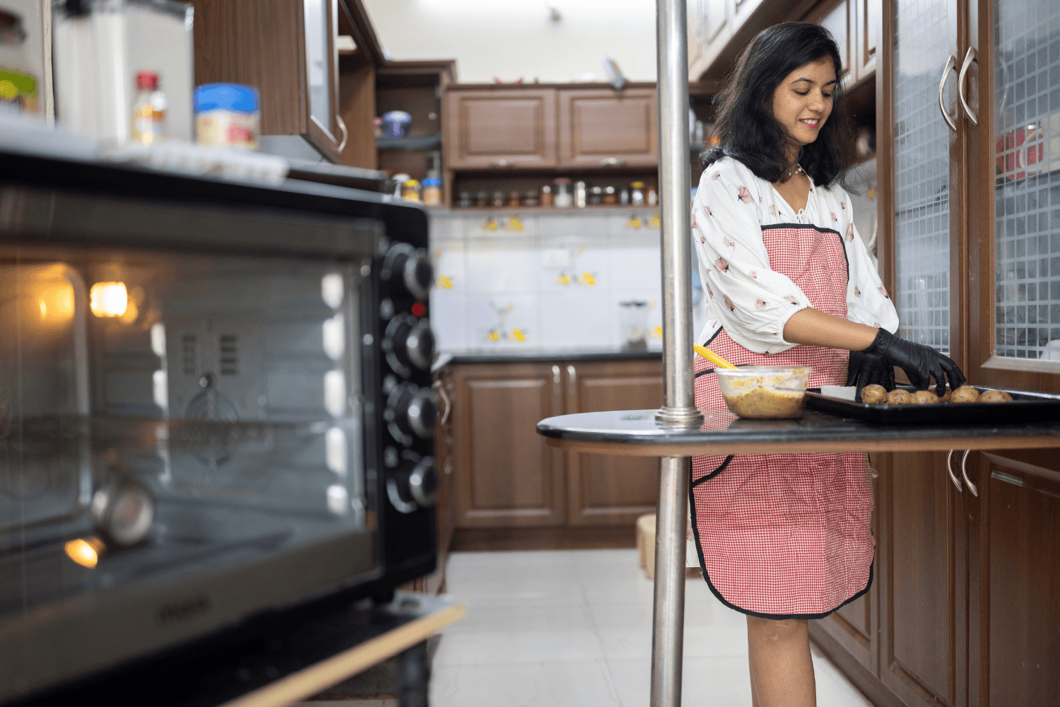 Prachi Robinson, a woman entrepreneur from India is standing in a kitchen preparing cookies.