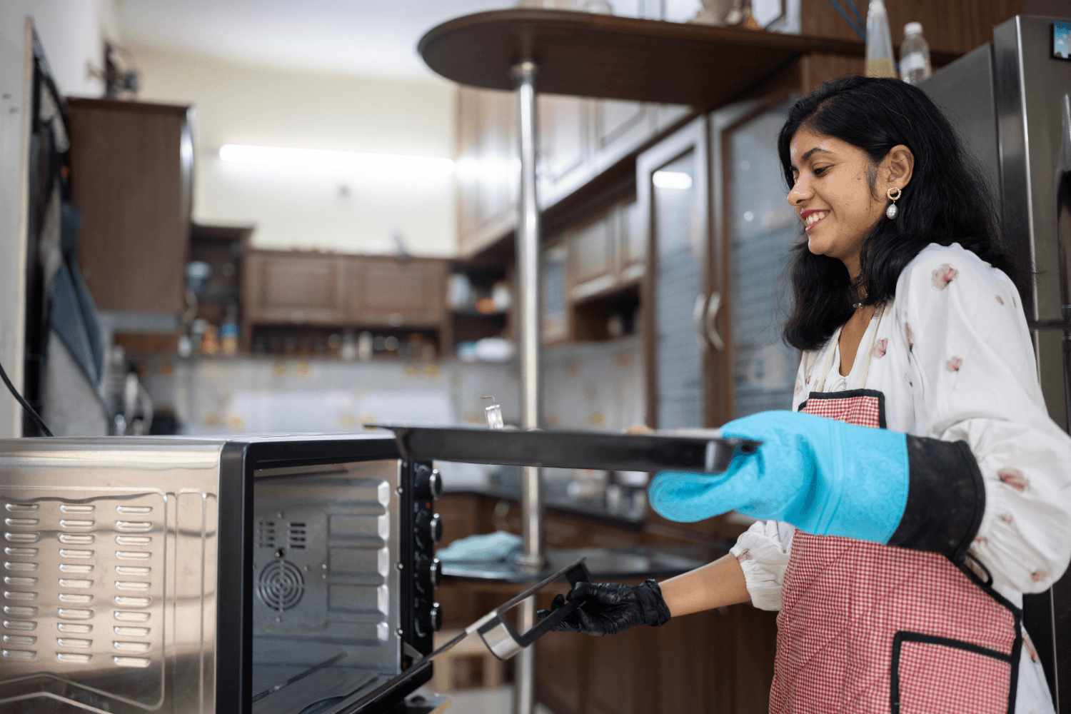 Prachi Robinson, a woman entrepreneur from India, puts cookies in the oven.