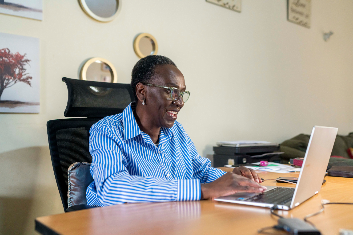 Frida Owinga, Owner of Passion Profit in Nairobi Kenya smiles at her desk.