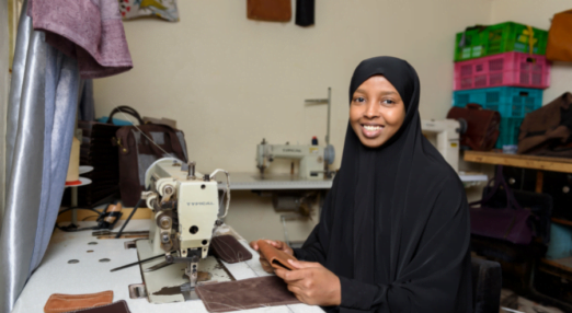 Muna Abi Elmi sewing a leather wallet
