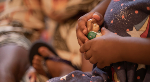 A toddler's hands holding a toy