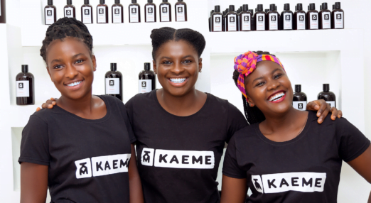 Freda, an entrepreneur and mentee from Ghana poses with staff at her business, Kaeme